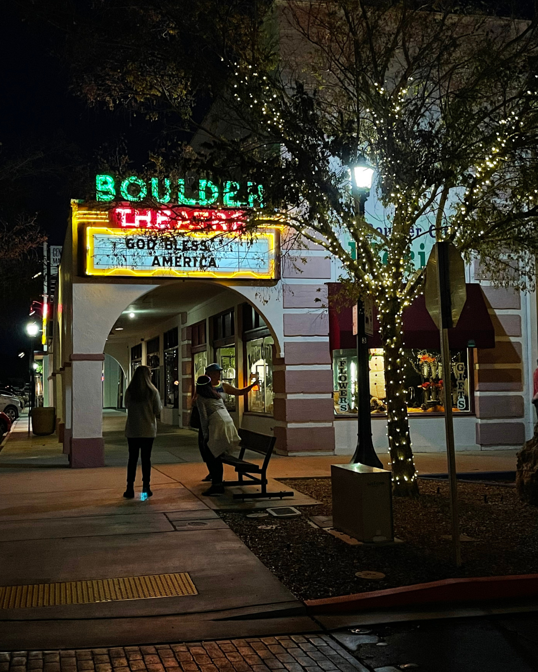 Boulder Theatre at night with two people walking by