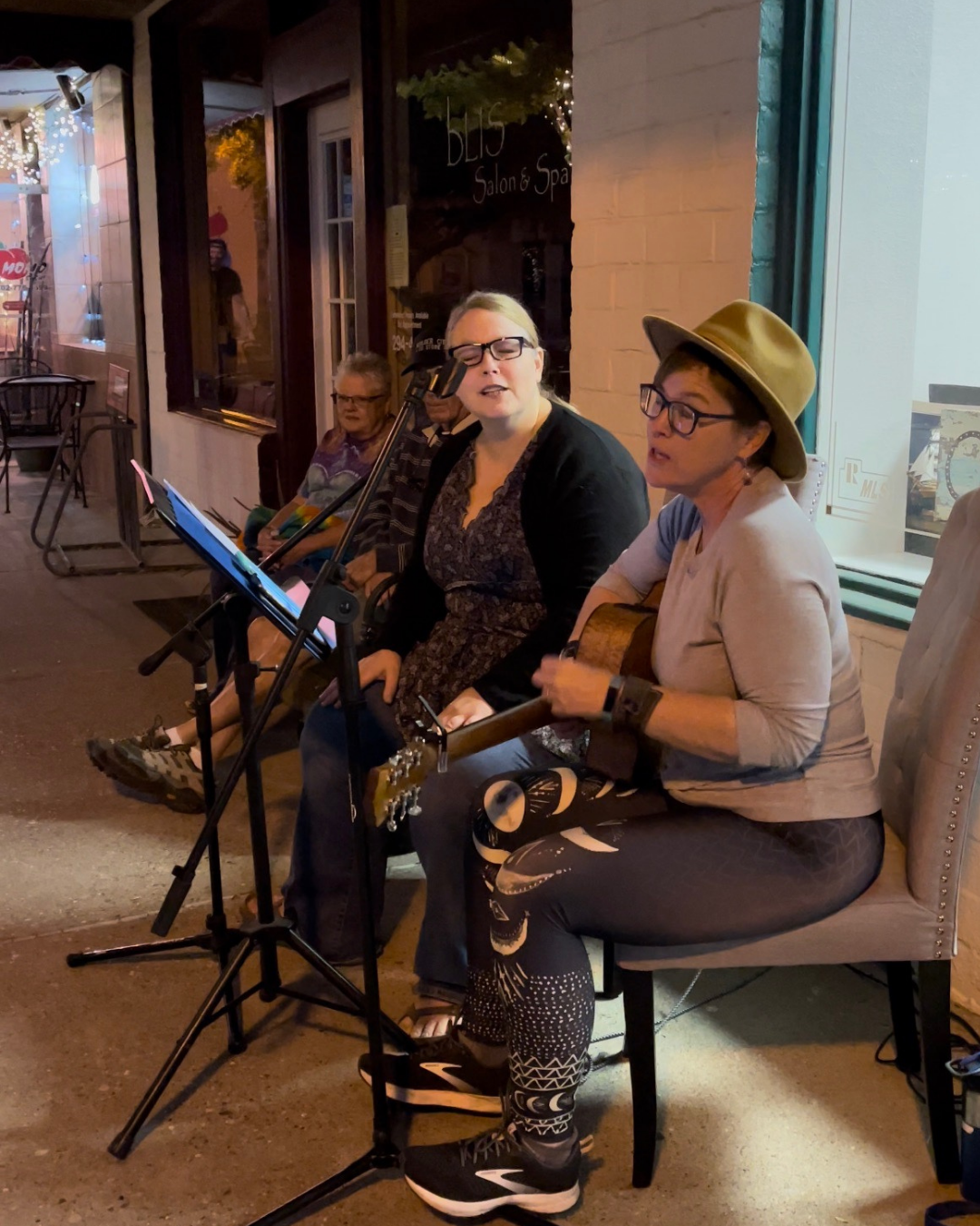 Two females signing with a man sitting next and listening