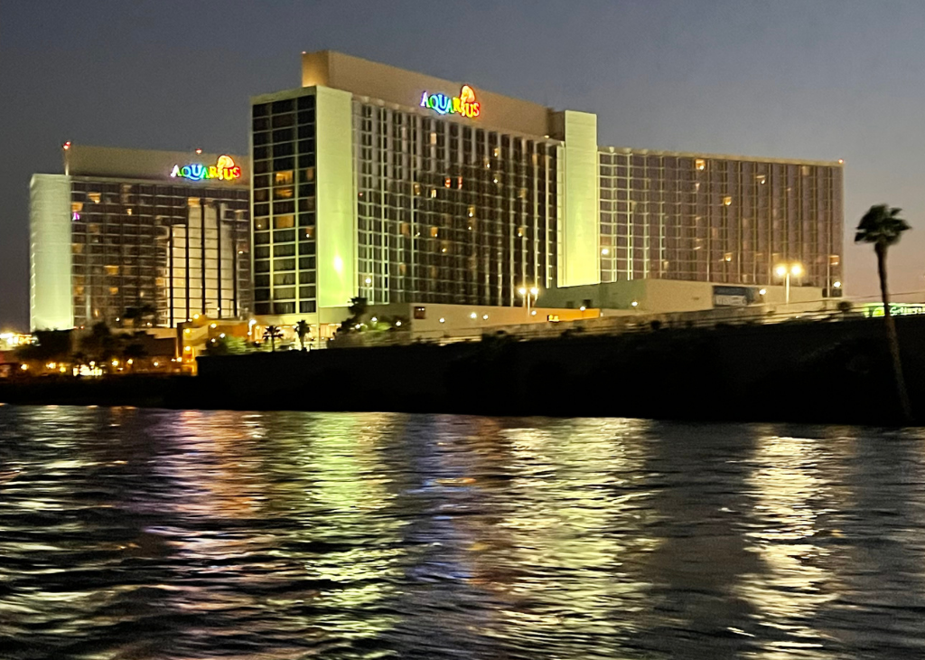 Aquarius Casino Resort in the background of cloudy night with the water shining bright from casino lights