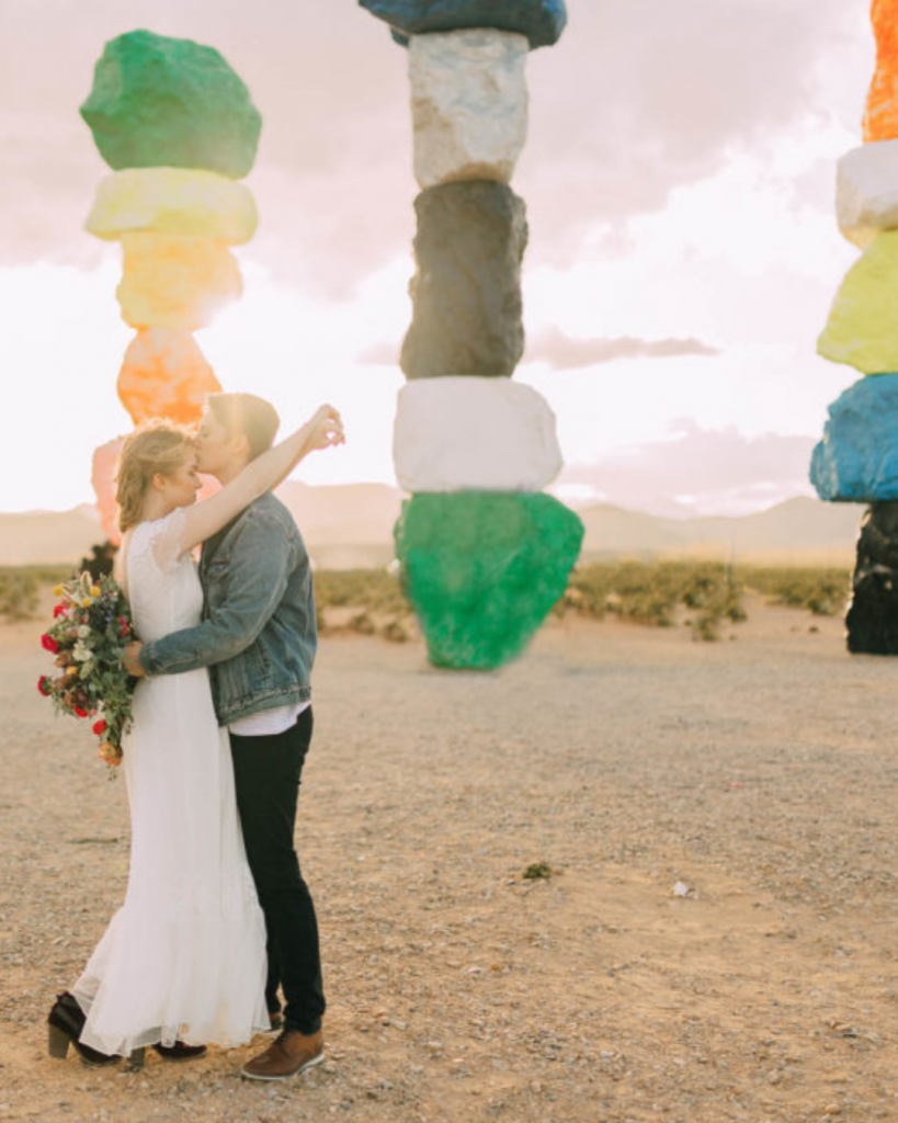 Couple kissing at the Seven Magic Mountains exhibit in Jean Nevada at sunset