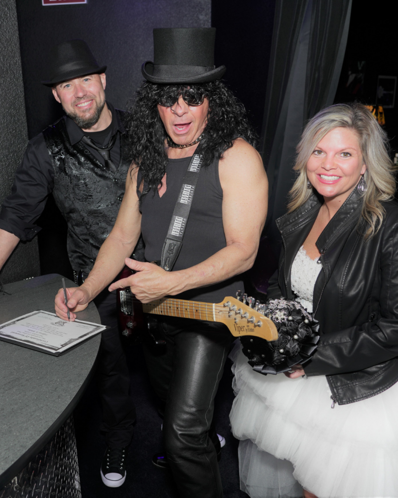 Couple Tiffany and Blake in between an entertainer impersonating Slash