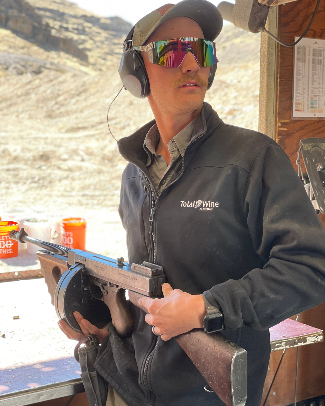 The gun attendant holding a tommy gun explaining safety.