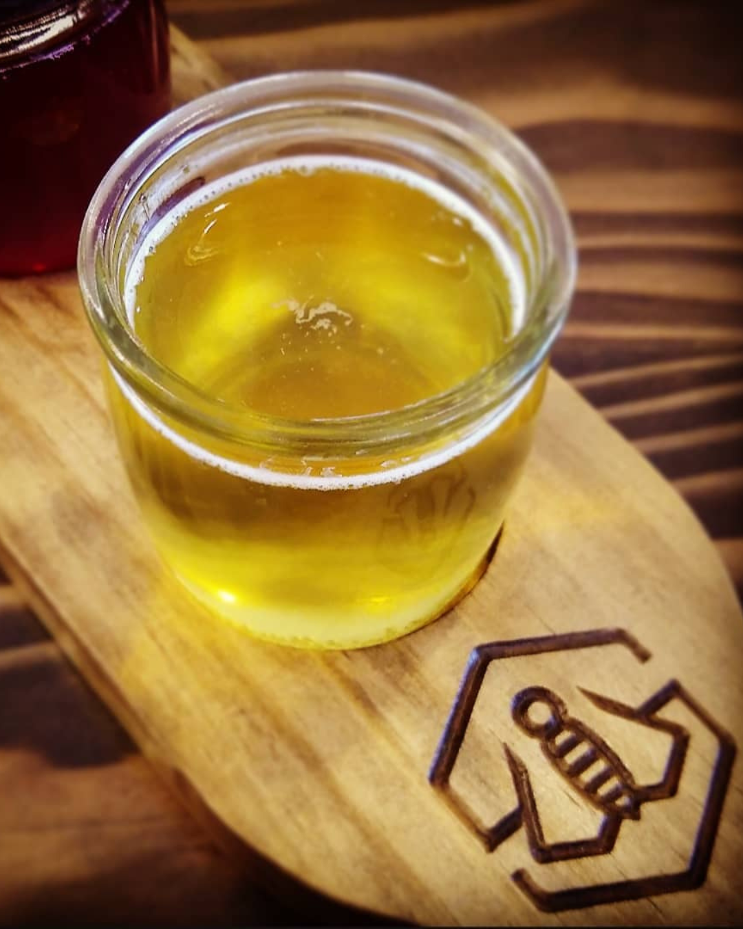 A wood table with a wood beer flight with a carved stonewise logo and two flights of beer
