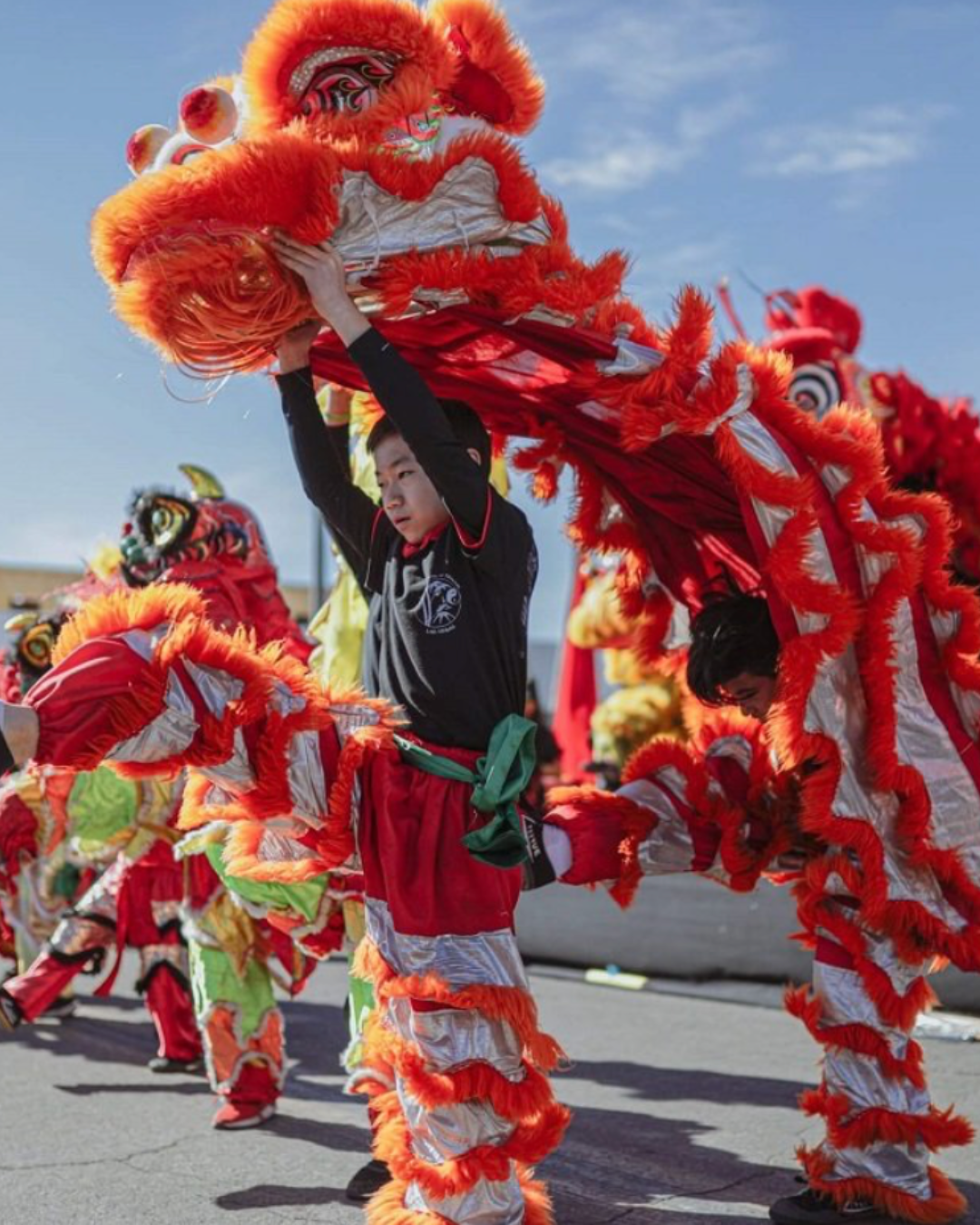 A boy putting on a dragon costume for the winter Chinese New Year in the Desert