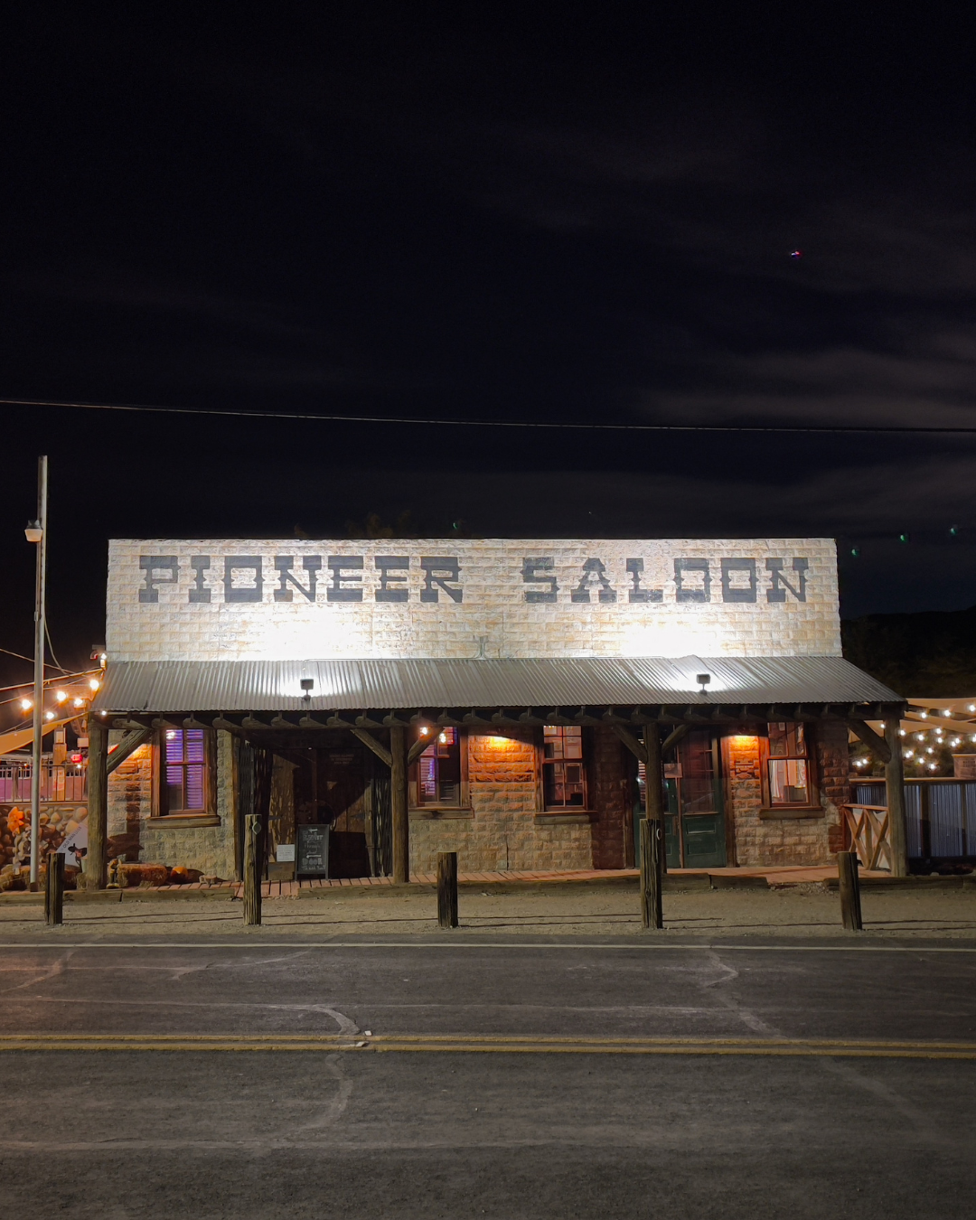 Pioneer Saloon front of building shot with a pitch black sky.