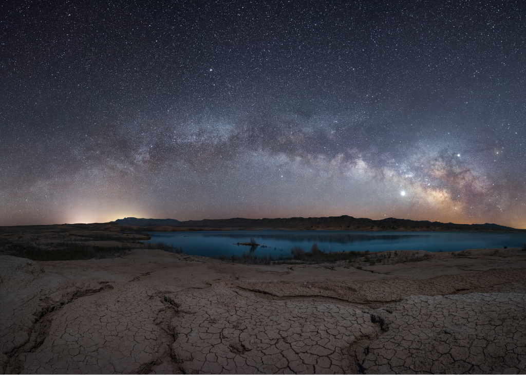 Dry lakebed foreground, lake background and milky way above