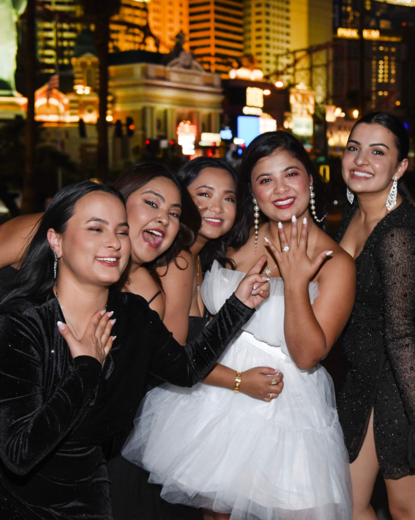a bride to be in a white dress on the strip with friends in black celebrating her bachelorette days going bye-bye.