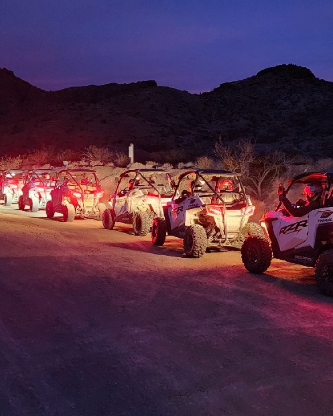 Awesome Adventures tour of 5 ATV's in the evening heading down a dirt road near Boulder City.