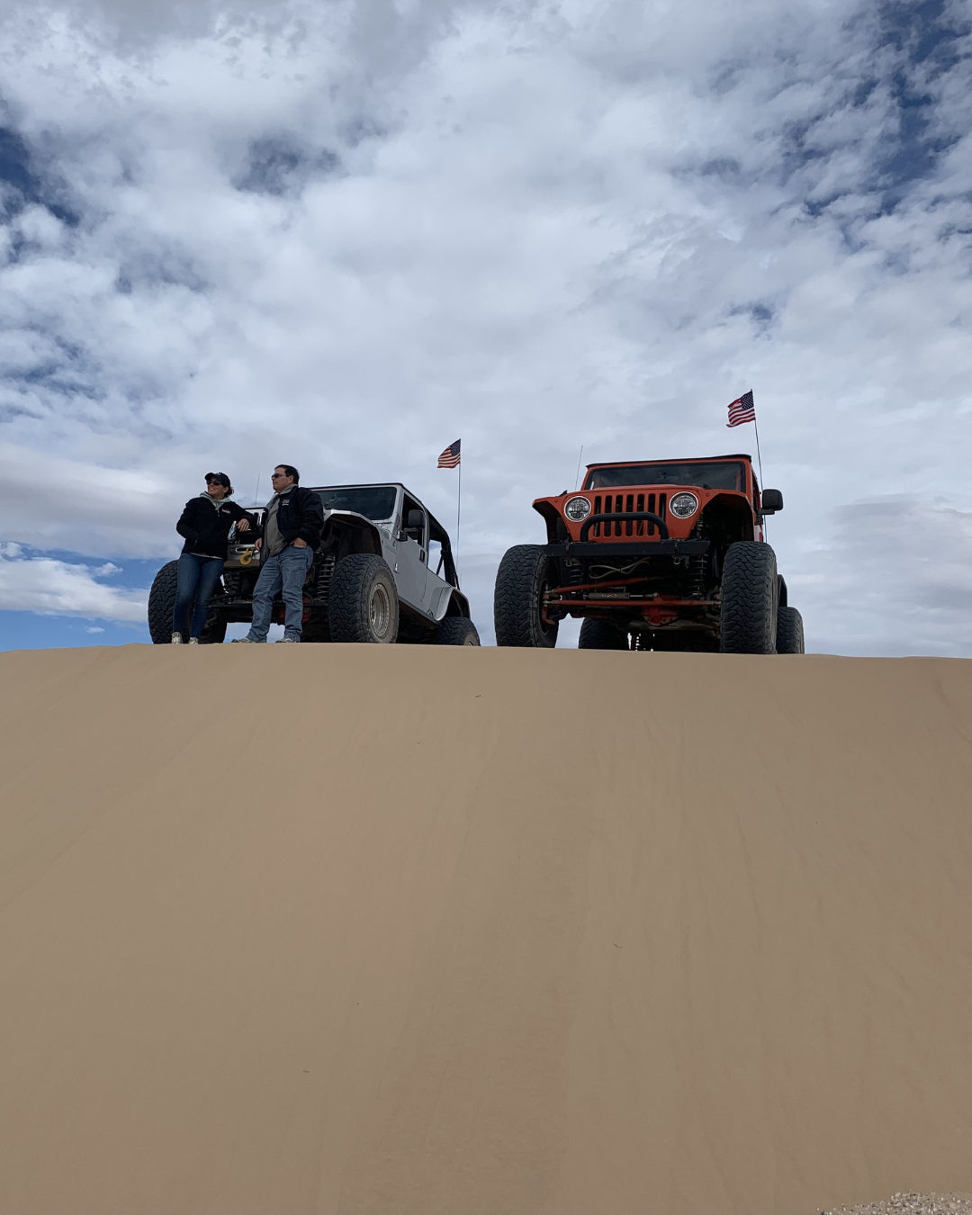 Two Las Vegas Rock Crawlers on a cloudy day getting ready to descend down a sand dune.