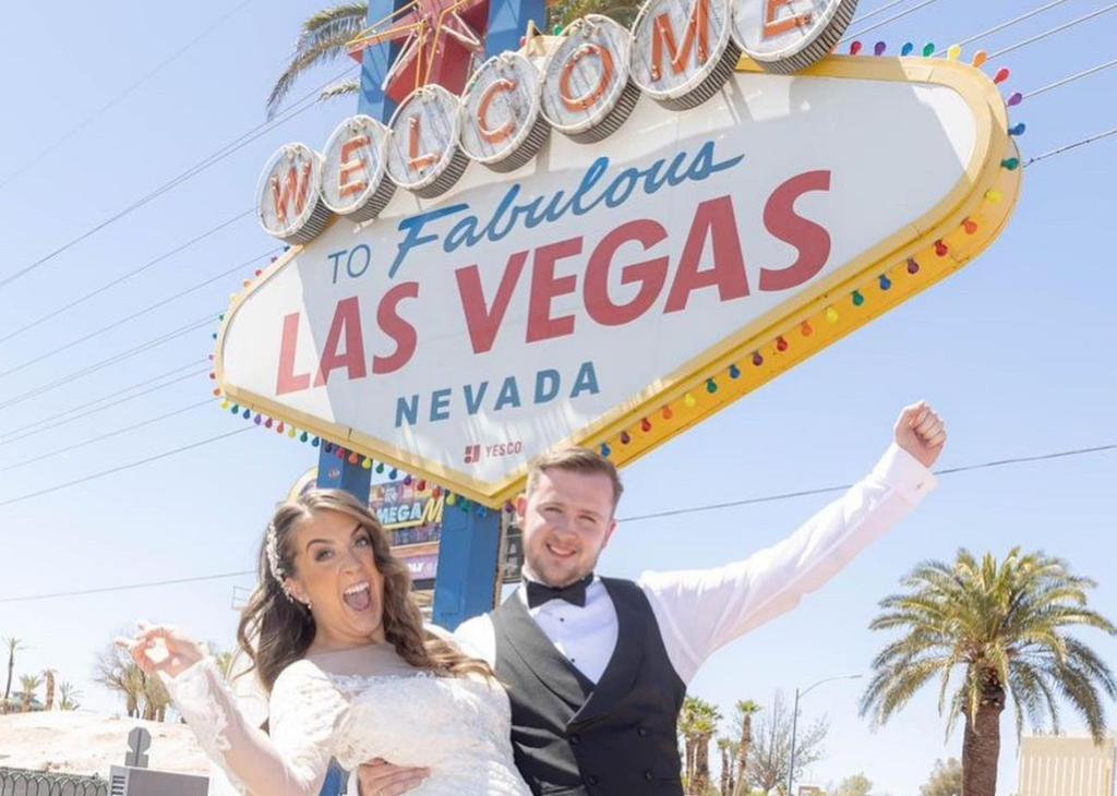 A wedding couple by Welcome to Las Vegas Sign.