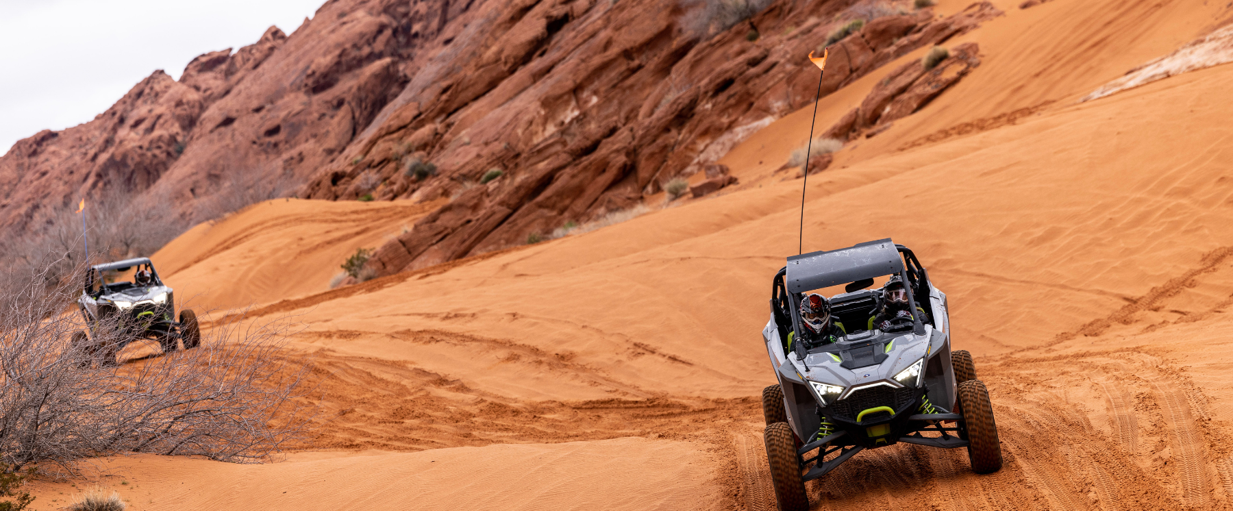 Ultimate Desert Adventures on Logandale Trails in Moapa Valley. Two UTVs on orange sand.