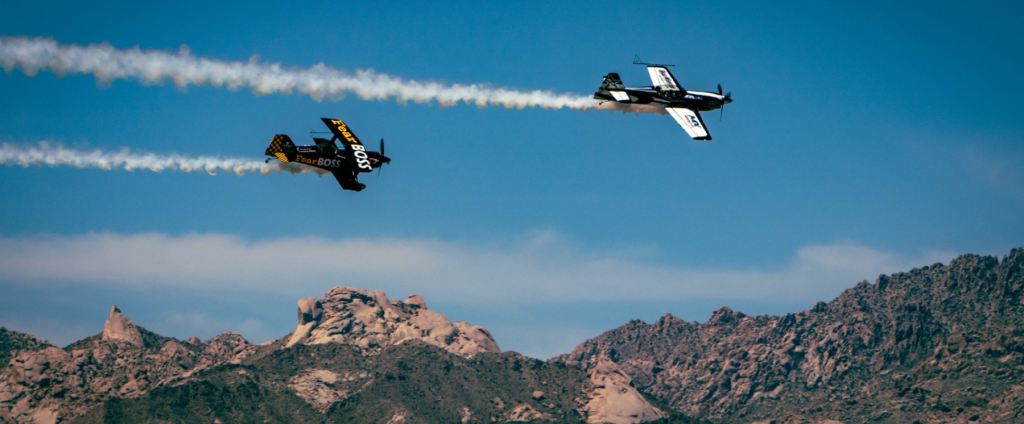 Two planes flying across the Laughlin area with mountains in the background during the 2023 airshow.