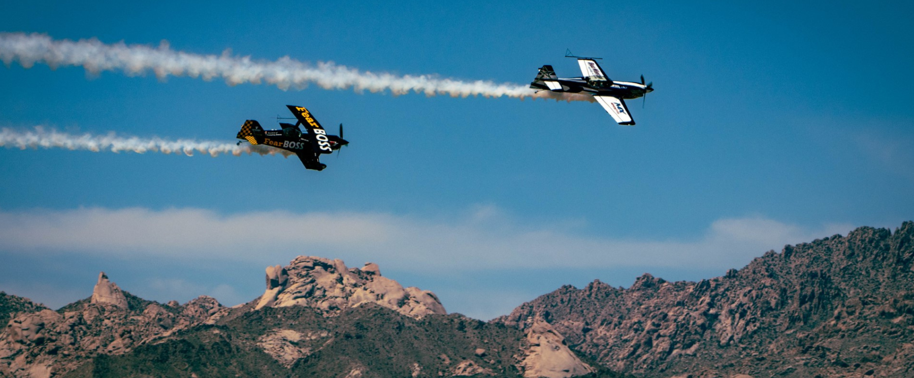 Two planes flying across the Laughlin area with mountains in the background during the 2023 airshow.