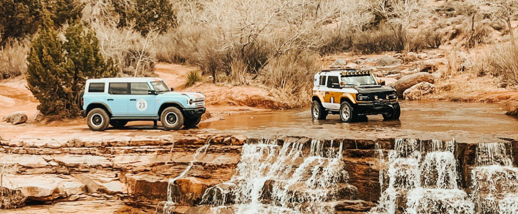 Two broncos (baby blue and white) sit next to a water fall at Lake Mead.