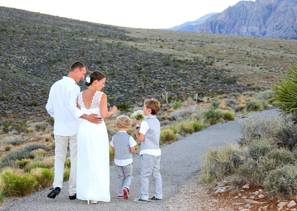 Bride and groom with two children walking together on a path