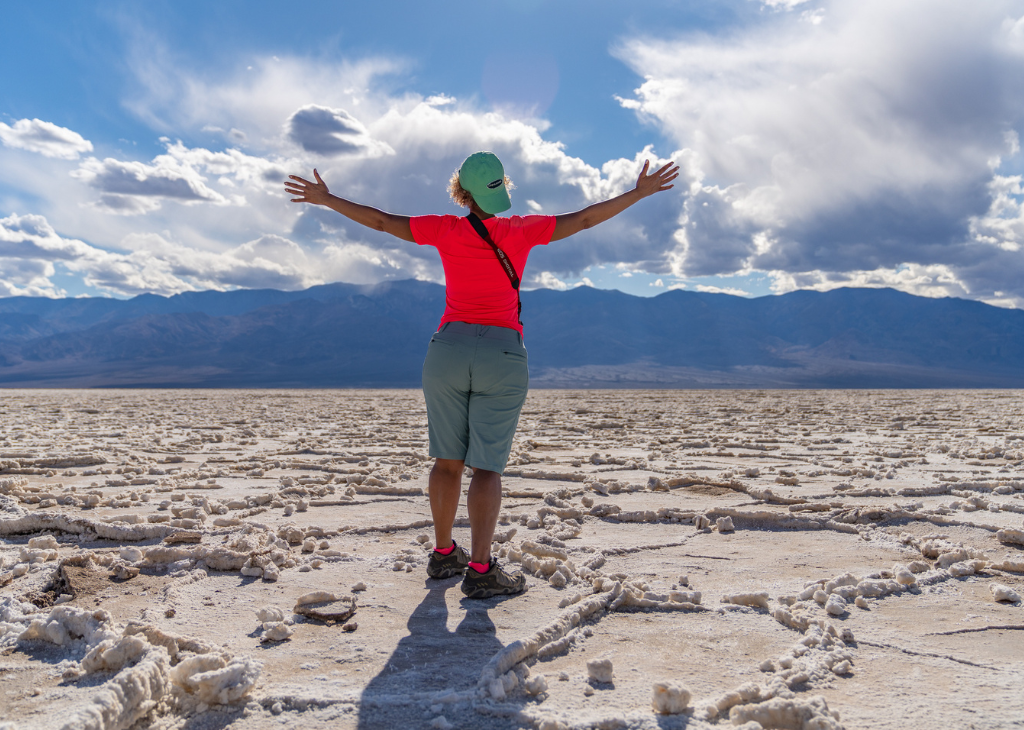 A person with their back to us staring at the vast desert of Death Valley. Photo courtesy of Elite Custom Adventures.