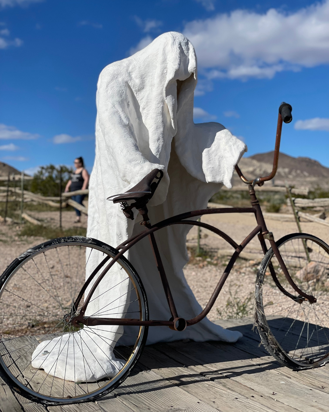 In this pic we are road tripping to Goldwell open air museum outside of Beatty Nevada - ghost like sculpture holding a bicycle..