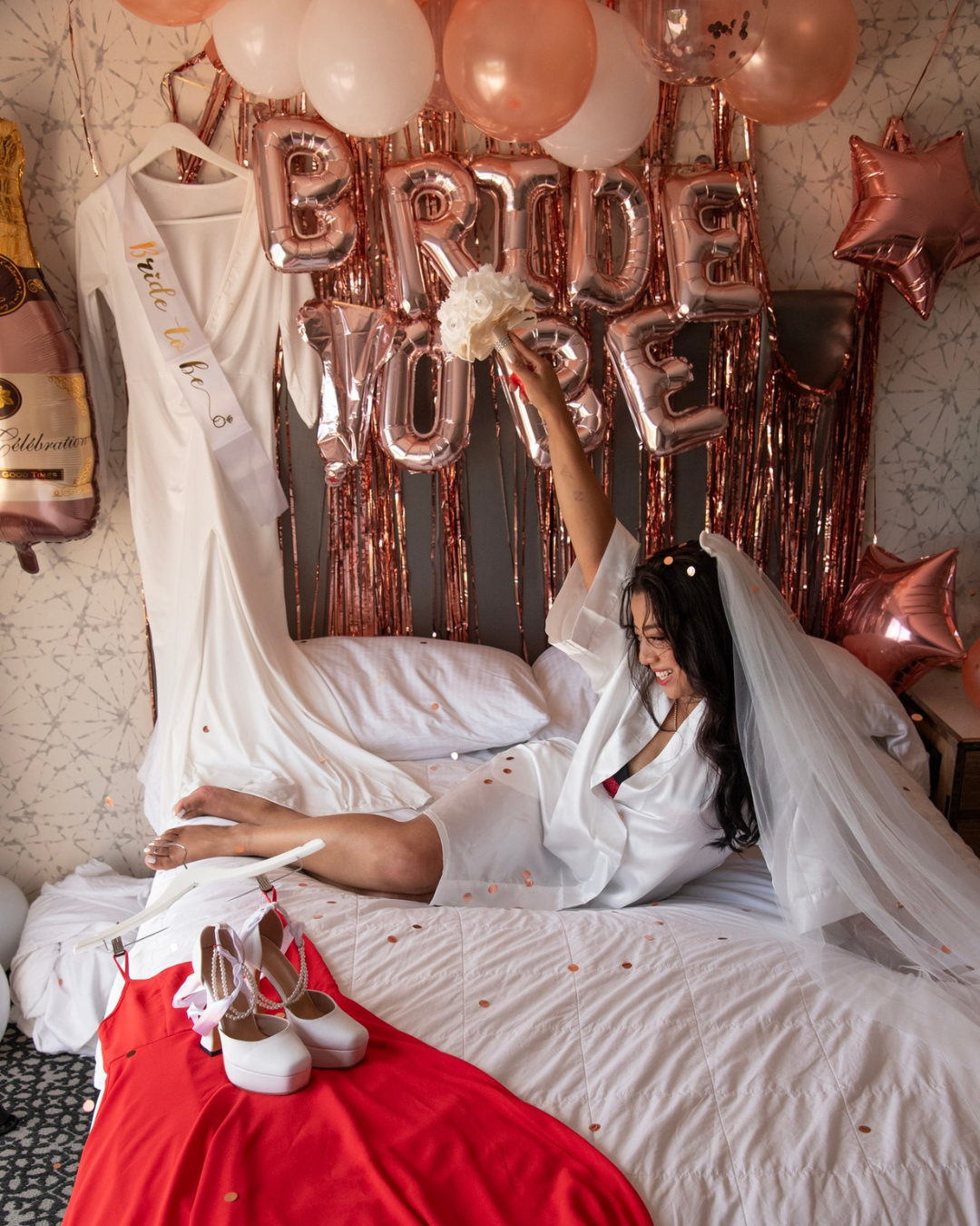 A bride in her hotel room with balloons that say Bride to BE.