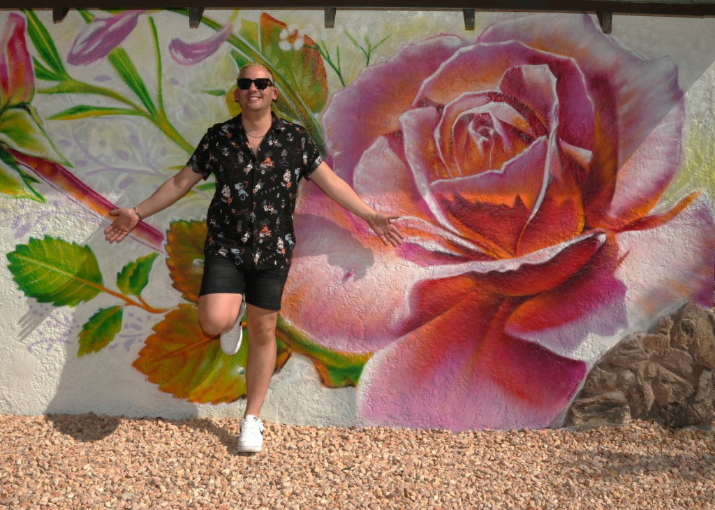 Las Vegas Territory 7 must do experiences on The Strip and beyond the Neon and a man pictured in front of a pink rose mural in downtown Las Vegas.