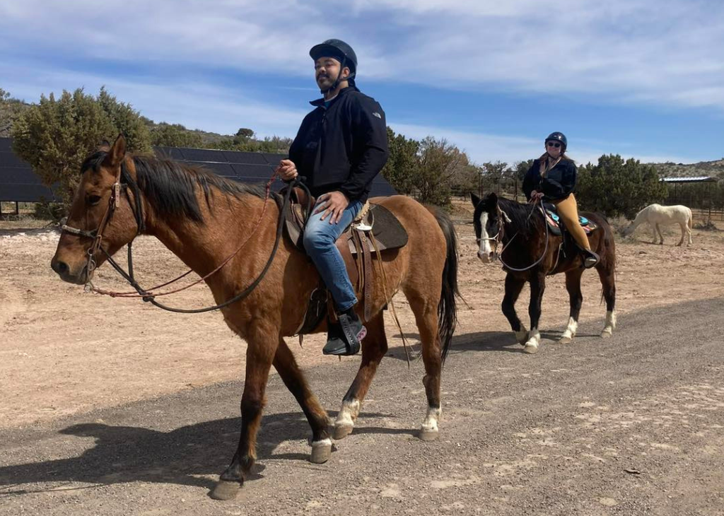 Las Vegas Outdoor Adventures has horseback riding options and two people are pictured on horses walking along a desert trail.