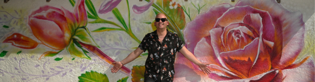 Plan your trip from The Strip to beyond Las Vegas neon, adventure is plenty. Pictured is a man on a Photo Tours Vegas shoot in front of a rose mural in downtown Las Vegas.