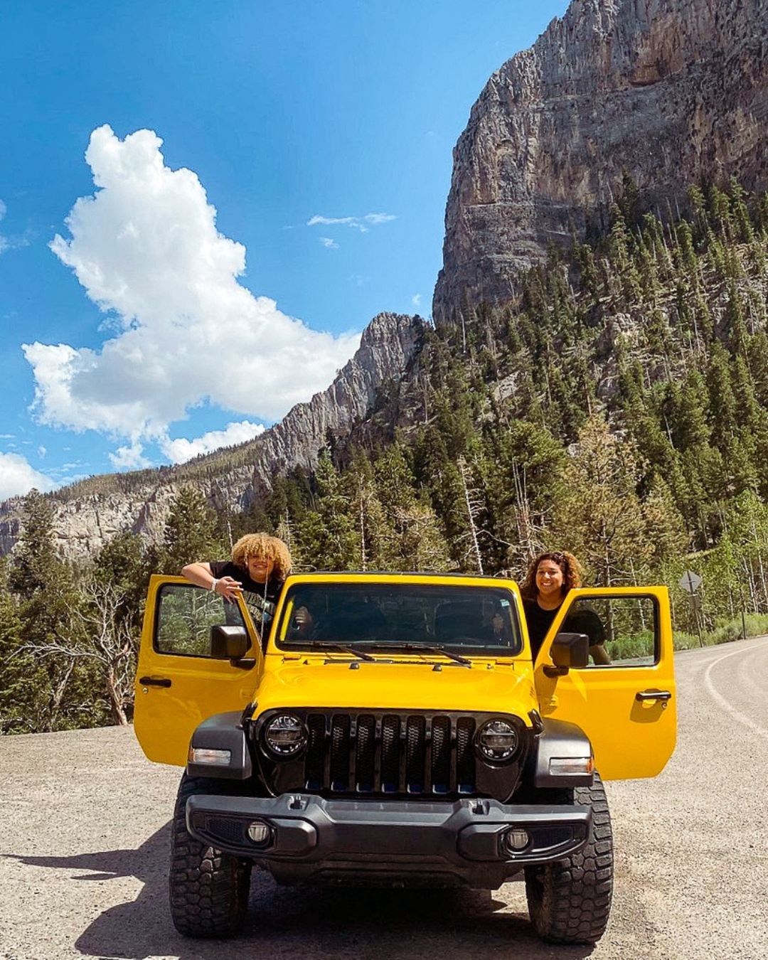 Two people posing in a jeep with a backdrop of Las Vegas Territory - mountains. Picture courtesy of Jeep Tours Las Vegas.