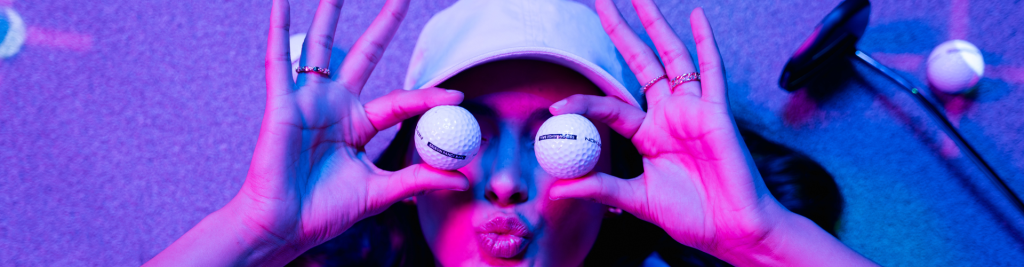 A person holding two golfballs over their eyes giving us duck lips to promote Atomic Golf in Las Vegas.