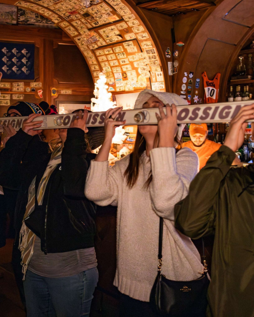 Group of people in front of a bar holding a sign in Las Vegas Territory.