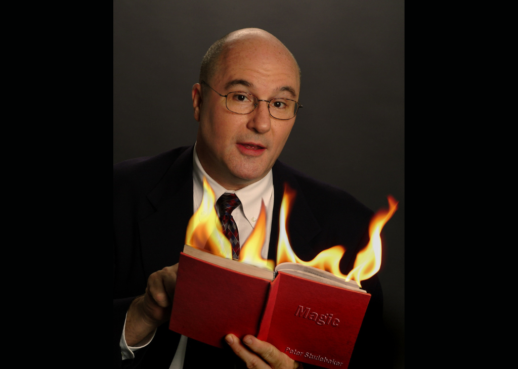 Peter Studebaker is a magician and the pic is him and magic book on fire.