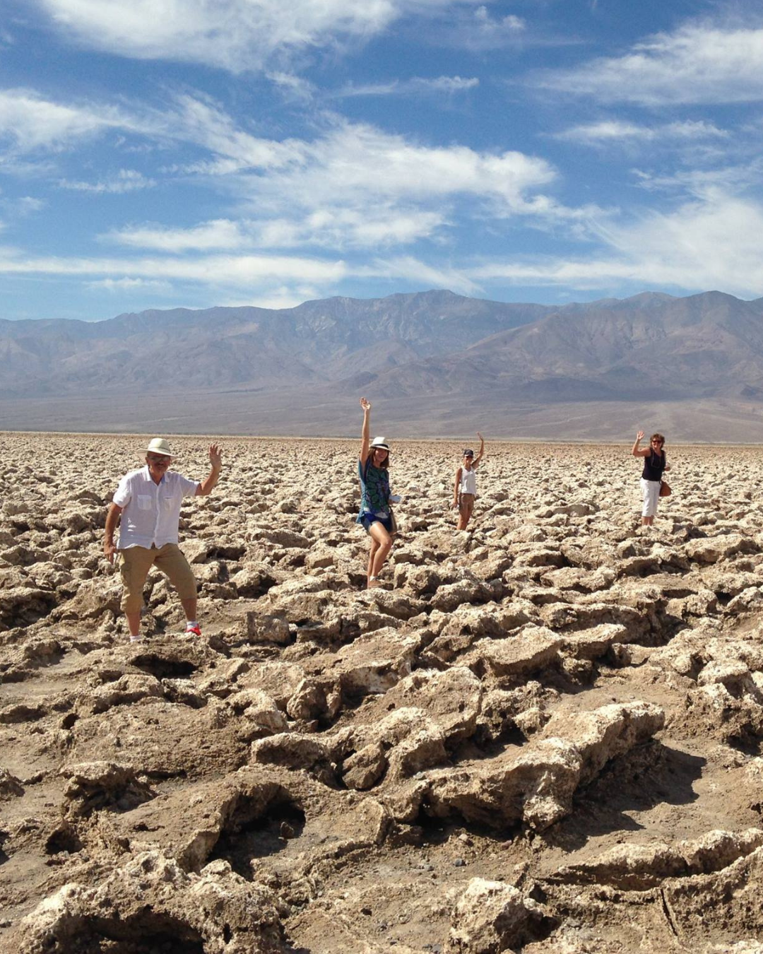 Four people waving on an Adventure Photo Tours road trip from Las Vegas To Death Valley.
