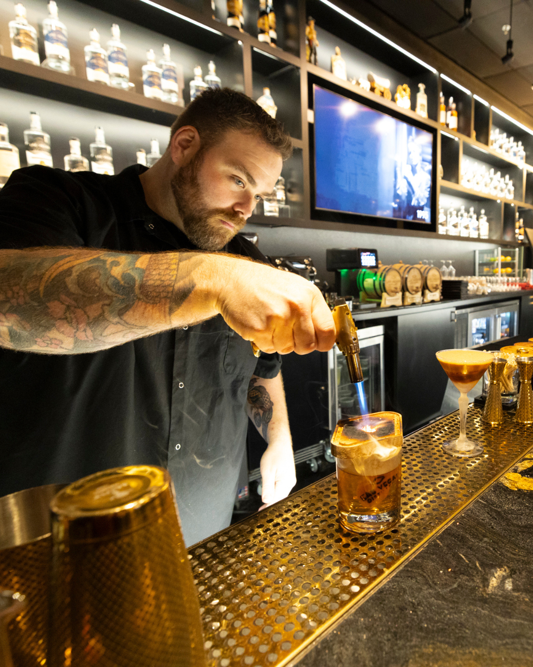 Destination Henderson Nevada. Photo: A bartender at the Las Vegas Distillery fires up a cocktail. Located in the Artisan Booze District of Henderson.