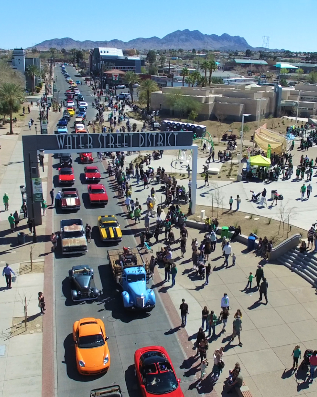 Destination: Water Street District in Henderson Nevada during Hot Rod Days. Shot from above: People walking and classic cars parked up and down the street.