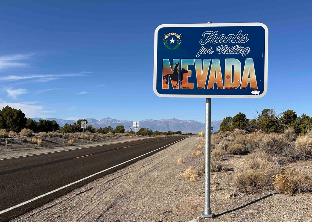 Recreate Responsibly when in Nevada. Picture shows a thank you for visiting Nevada sign next to a road with mountains in the background.
