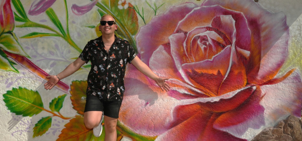 Las Vegas Territory 7 must do experiences on The Strip and beyond the Neon and a man pictured in front of a pink rose mural in downtown Las Vegas.